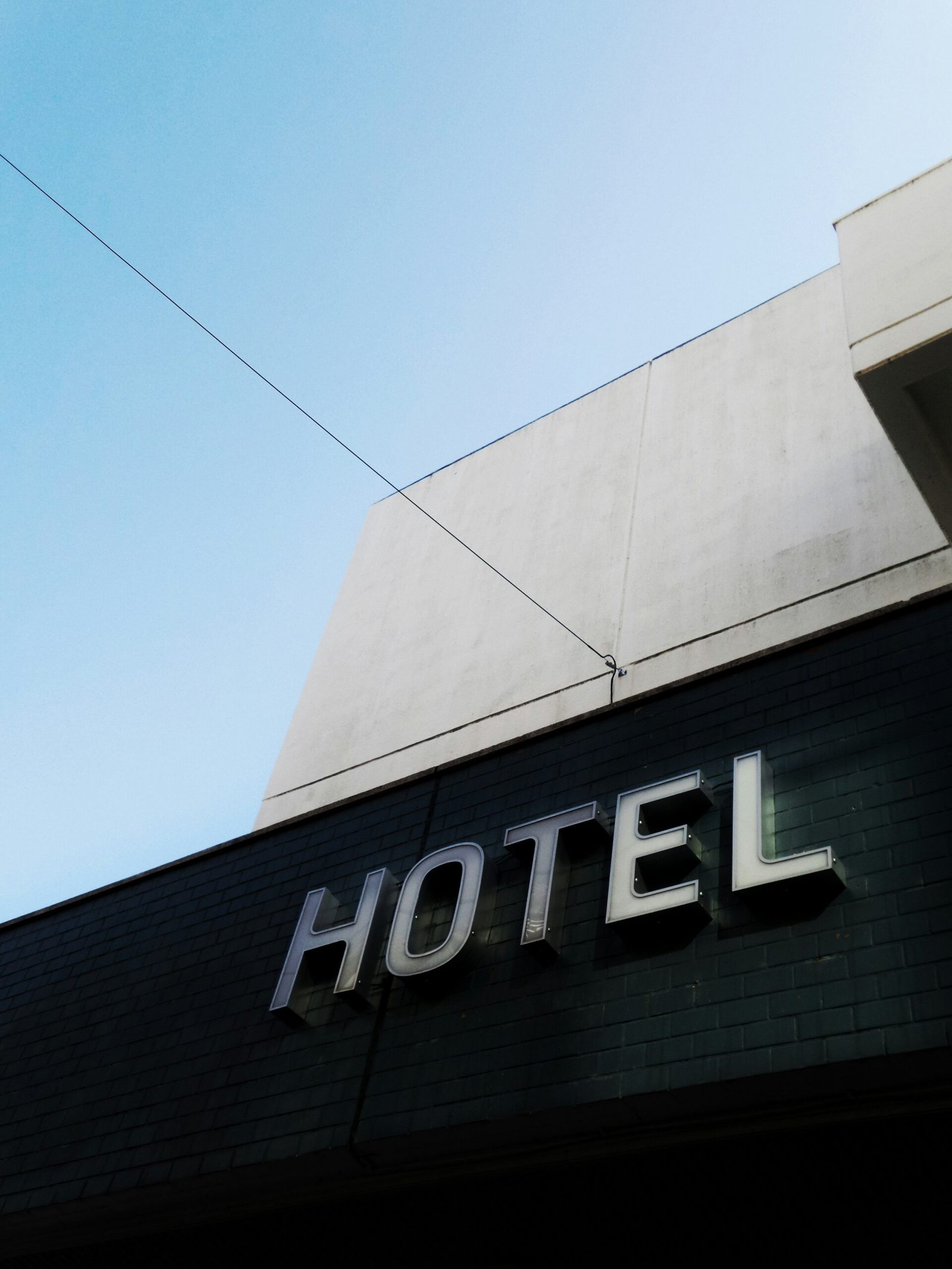 black and white concrete hotel building under a calm blue sky