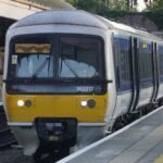 a yellow and white train pulling into a train station