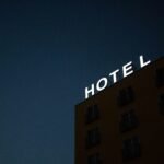 low-angle photo of Hotel lighted signage on top of brown building during nighttime